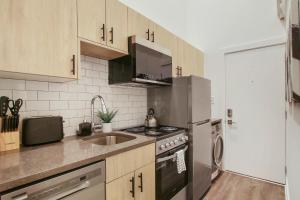 a kitchen with a stainless steel refrigerator and a sink at Complete and Minimalist Studio Apt - Wilson 101 in Chicago