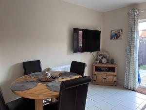 a dining room table with chairs and a tv on the wall at Centrally Located Lincolnshire Home With Free Parking On Premises in Lincolnshire
