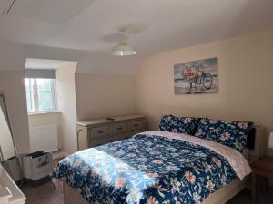 a bedroom with a bed with a blue floral comforter at Centrally Located Lincolnshire Home With Free Parking On Premises in Lincolnshire