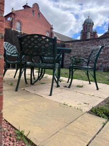 two benches sitting on a sidewalk in front of a building at Centrally Located Lincolnshire Home With Free Parking On Premises in Lincolnshire