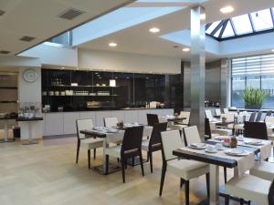 una sala da pranzo con tavoli e sedie e una cucina di Hotel Falko a Meise