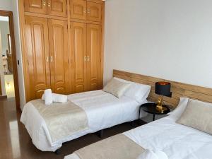 een slaapkamer met 2 bedden en een kast bij Casa Almendro in Jumilla