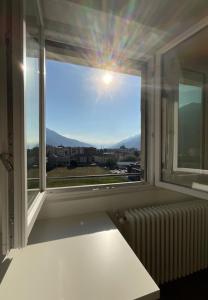 a window with a radiator and a view of a city at Settimo Cielo Apartment Aosta CIR 0199 in Aosta