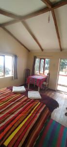 a room with two beds and a large rug at Inka Wasi in Isla de Sol