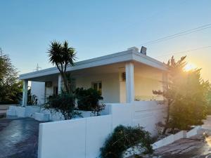 dom z białym płotem przed nim w obiekcie Villa Bella Luna with Pool - Puglia Mia Apartments w mieście Monopoli