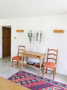 a table with two chairs and a vase with flowers at Chalet la Tulipe, mountain view, Terrace, BBQ in Nendaz +17 photos