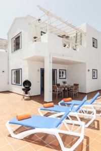 a group of lounge chairs and a grill in a room at Luxury Beach Fayna in Playa Honda