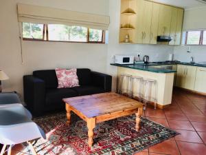 Witzenberg Guest Farm في Wolseley: غرفة معيشة مع أريكة وطاولة قهوة