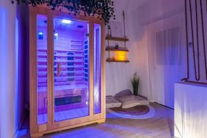 Habitación con puerta a un balcón con luces moradas. en Le Lovely Narbonnais - Balneo & Sauna, en Narbona
