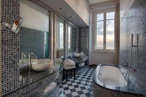 a bathroom with a tub and two sinks in it at GH Palazzo Suite & SPA in Livorno