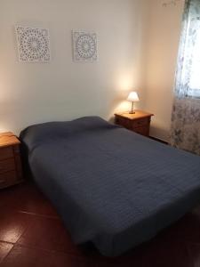 a bedroom with a blue bed and two night stands at Casa do Poço in Quinta do Anjo