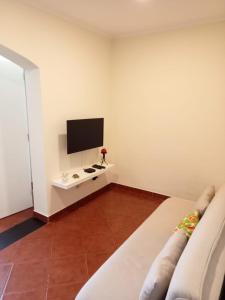 a living room with a couch and a tv at Casa do Poço in Quinta do Anjo