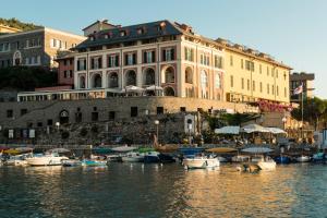 a large building with boats docked in a harbor at Grand Hotel Portovenere in Portovenere