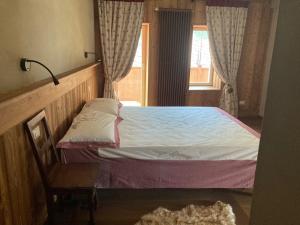 uma pequena cama num quarto com uma janela em La Noix - Alloggi ad uso turistico - VDA - ARVIER - n 0041 e n 0042 em Arvier