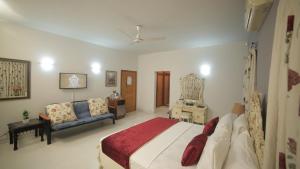a bedroom with a large bed and a couch at Four Squares Karachi in Karachi