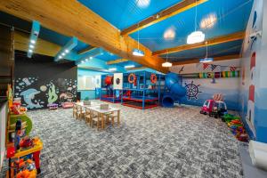 a play room with a table and a playground at Hotel Jan in Darlowko