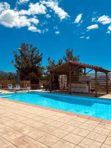 a swimming pool with a gazebo and a blue sky at Villa Kastro Elassona in Elassona