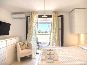 ein Schlafzimmer mit einem Bett und einem Stuhl und einem Fenster in der Unterkunft Ideal Rooms in Porto Cesareo