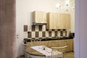 a kitchen with a table and chairs and a chandelier at L'hôtel de Police - Topdestination-Spa in Spa