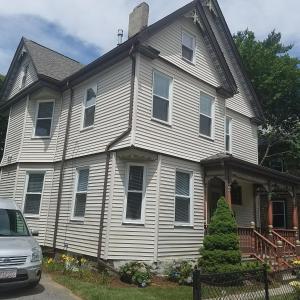 a white house with a car parked in front of it at Large Suite w/ Private Bath,great location in Boston