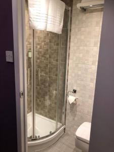 La salle de bains est pourvue d'une douche en verre et de toilettes. dans l'établissement Brighton Surf Guest House, à Brighton et Hove