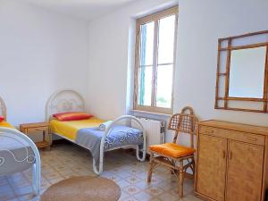 um quarto com uma cama, uma cadeira e janelas em Eco House San Michele em San Michele