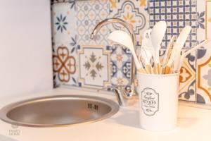 a cup of toothbrushes is next to a sink at Family Home in Quartu SantʼElena