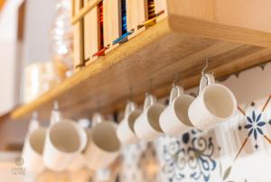 una fila de tazas de café colgando de una pared en Family Home, en Quartu SantʼElena 24 fotos más