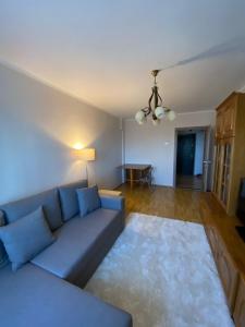 ein Wohnzimmer mit einem blauen Sofa und einem Tisch in der Unterkunft Sunrise Apartment in Constanţa