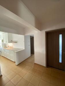 a large kitchen with white cabinets and a counter at Sunrise Apartment in Constanţa