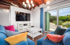 ein Wohnzimmer mit einem blauen Sofa und einem TV in der Unterkunft Vila s jacuzzijem i bazenom Mavrinac in Nerezine