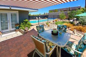 a patio with a table and chairs and a pool at 4 Mi to Beach Lake Havasu Apartment with Pool! in Lake Havasu City