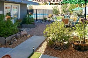 a garden with a patio with a table and chairs at 4 Mi to Beach Lake Havasu Apartment with Pool! in Lake Havasu City
