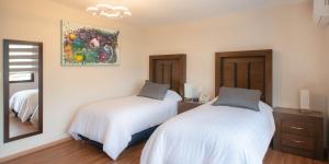 una camera da letto con due letti e uno specchio di Hotel Posada XR a Córdoba