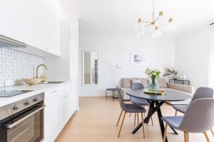 a kitchen and dining room with a table and chairs at UKIEL PARK 20 - Apartament Superior 2 sypialnie przy Plaży Miejskiej in Olsztyn