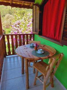 a wooden table and chairs on a balcony at Casa Canto Verde in Visconde De Maua