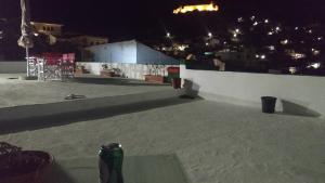 a bottle of beer sitting on a rooftop at night at Villa Kotetsi - Rooms To Let - Volissos - Chios in Volissos