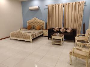 ein Wohnzimmer mit einem Bett, einem Sofa und Stühlen in der Unterkunft Royal Family Suite E-11 Only for Families Islamabad in Islamabad