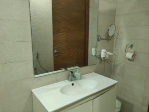 ein Badezimmer mit einem Waschbecken, einem Spiegel und einem WC in der Unterkunft Royal Family Suite E-11 Only for Families Islamabad in Islamabad