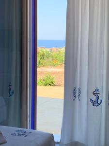 a room with a window with a view of the ocean at Residenza “La Vecchia Ancora” in Castelsardo