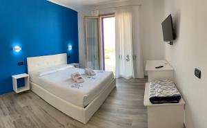 a bedroom with a white bed and a blue wall at Residenza “La Vecchia Ancora” in Castelsardo