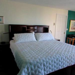 a bedroom with a large bed with white sheets at Swapscott Beachfront Vacation Home for Families in Phillips Point +2 photos