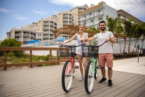 a man and a woman riding bikes on a boardwalk at Mahalo Diamond Beach Resort in Wildwood Crest