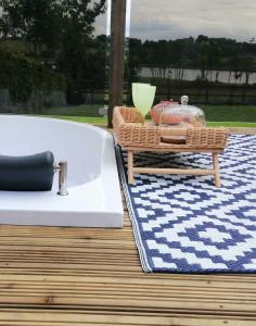 a bath tub sitting on a deck next to a table at Luxury Glamping with lake & Mountain View in Culky