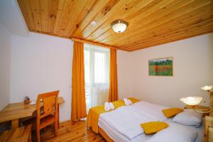 a bedroom with a bed and a desk and a window at Alpenhaus Kazbegi Hotel & Restaurant in Stepantsminda