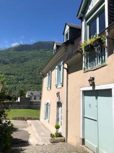 a house with a blue garage door and a mountain at Chambre privée Luz in Luz-Saint-Sauveur
