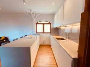 eine Küche mit weißen Schränken und einer Arbeitsplatte in der Unterkunft Apartment Alegría in Playa Honda