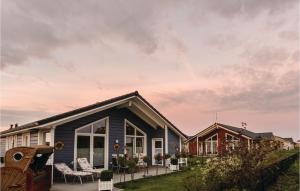 ein blaues Haus mit einer Terrasse davor in der Unterkunft Stunning Home In Dagebll With 2 Bedrooms, Sauna And Wifi in Dagebüll