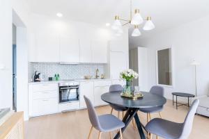 a kitchen and dining room with a table and chairs at UKIEL PARK 20 - Apartament Superior 2 sypialnie przy Plaży Miejskiej in Olsztyn +23 photos