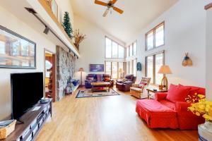 a living room with a red couch and a tv at Elk Ridge Retreat #3098 in Estes Park